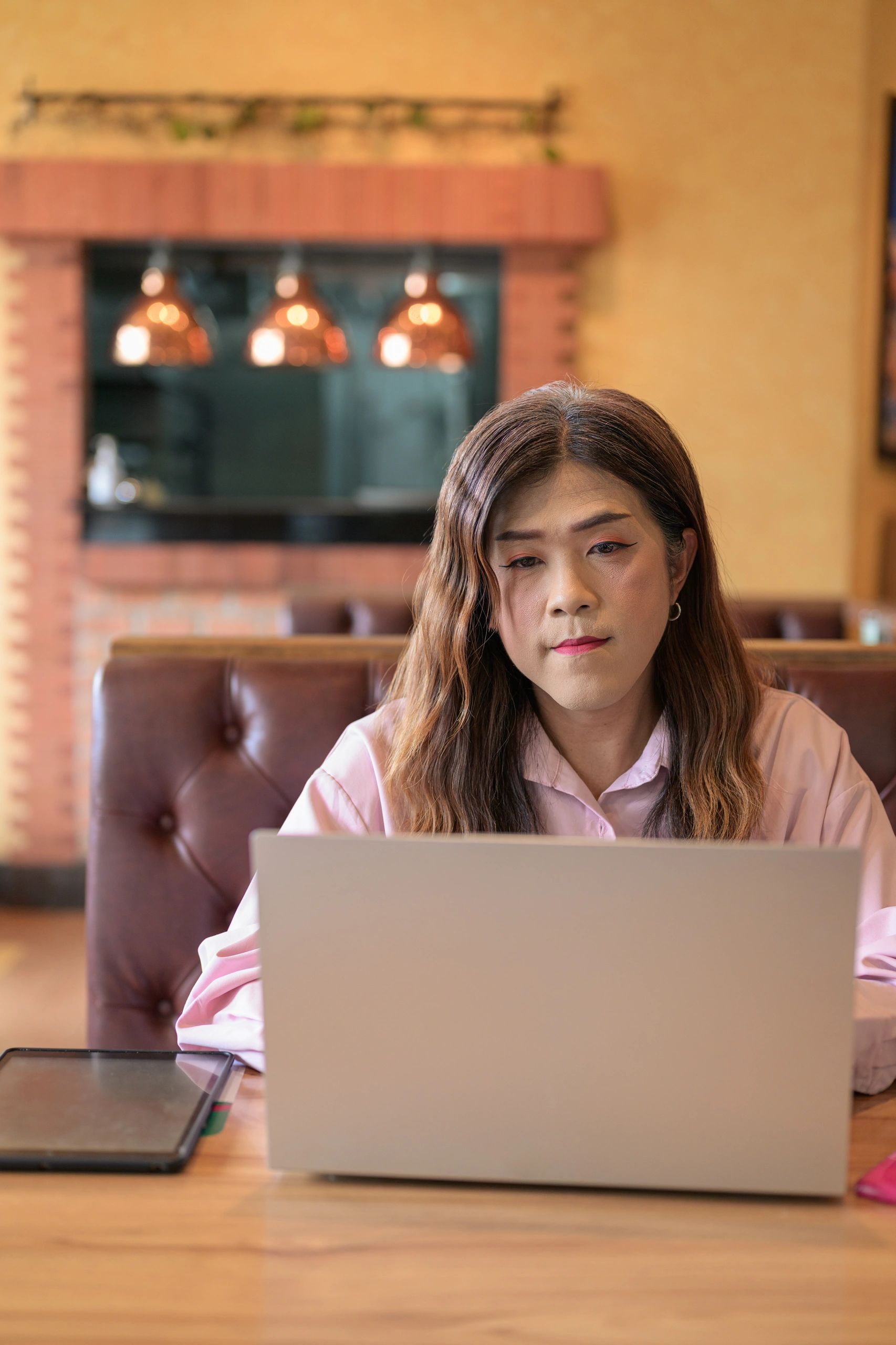 Asian writer working on a laptop in an editorial setting